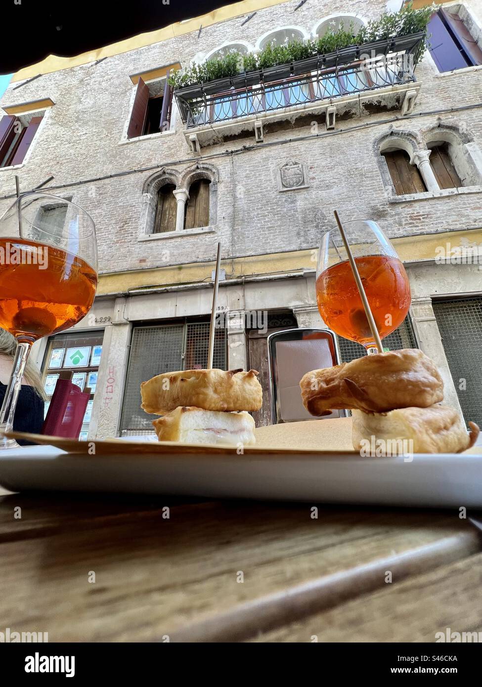 Enjoying Aperol Spritz and appetizers outside Salizada del Pistor street in Cannaregio, Venice - Smartphone Captured Stock Image