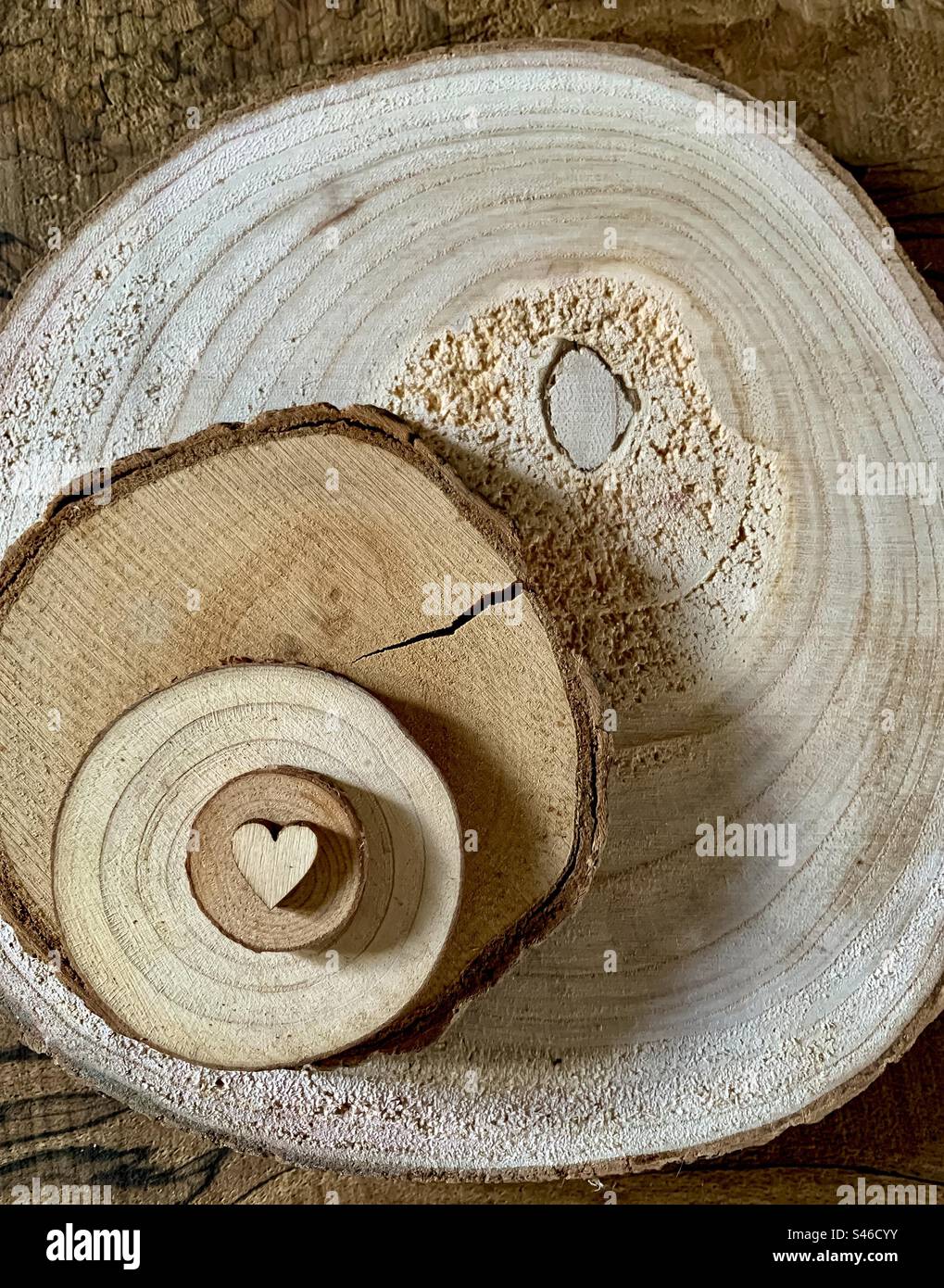 A wooden heart on increasing sized discs on wood - Smartphone Captured Stock Image