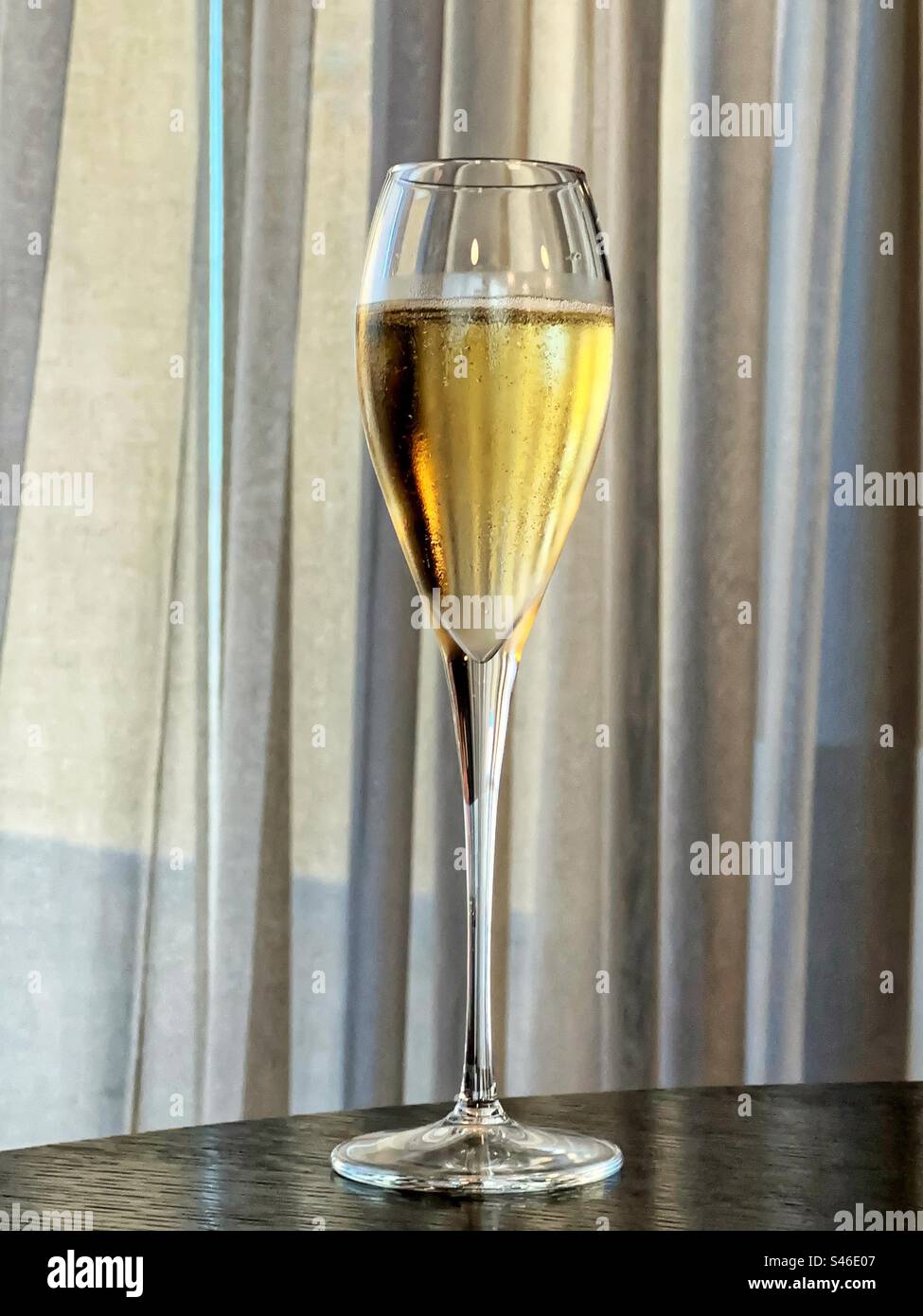 Glass of chilled champagne on a table in a hotel - Smartphone Captured Stock Image