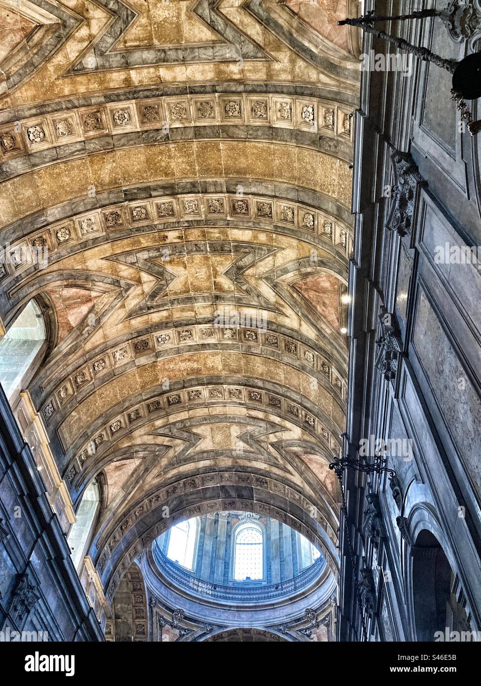 Detail of Basilica da Estrela church, in Lisbon, interior decoration ( with light coming through the dome). With yellow,pink,grey and black marble material. - Smartphone Captured Stock Image
