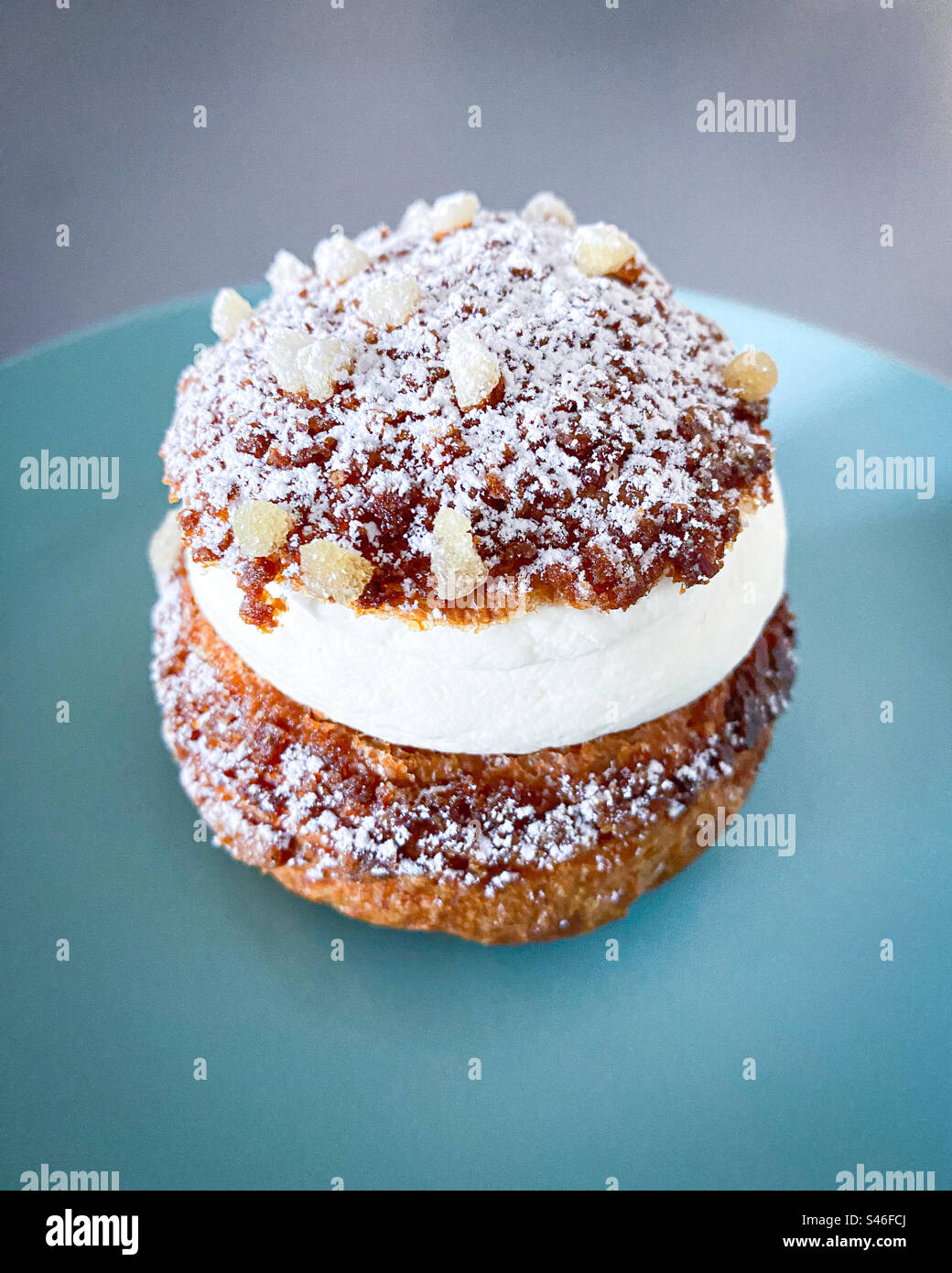 Crème puff dessert on turquoise plate, uneaten. - Smartphone Captured Stock Image