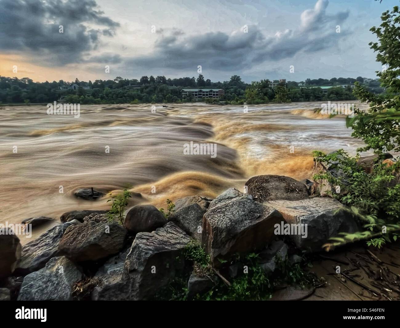 Dark storm clouds hang over a raging t James River in Richmond, VA. Stock Photo