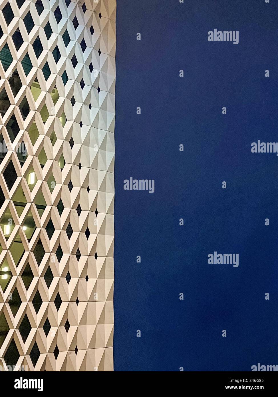 Close-up abstract shot of geometric façade against night sky with copy space. - Smartphone Captured Stock Image