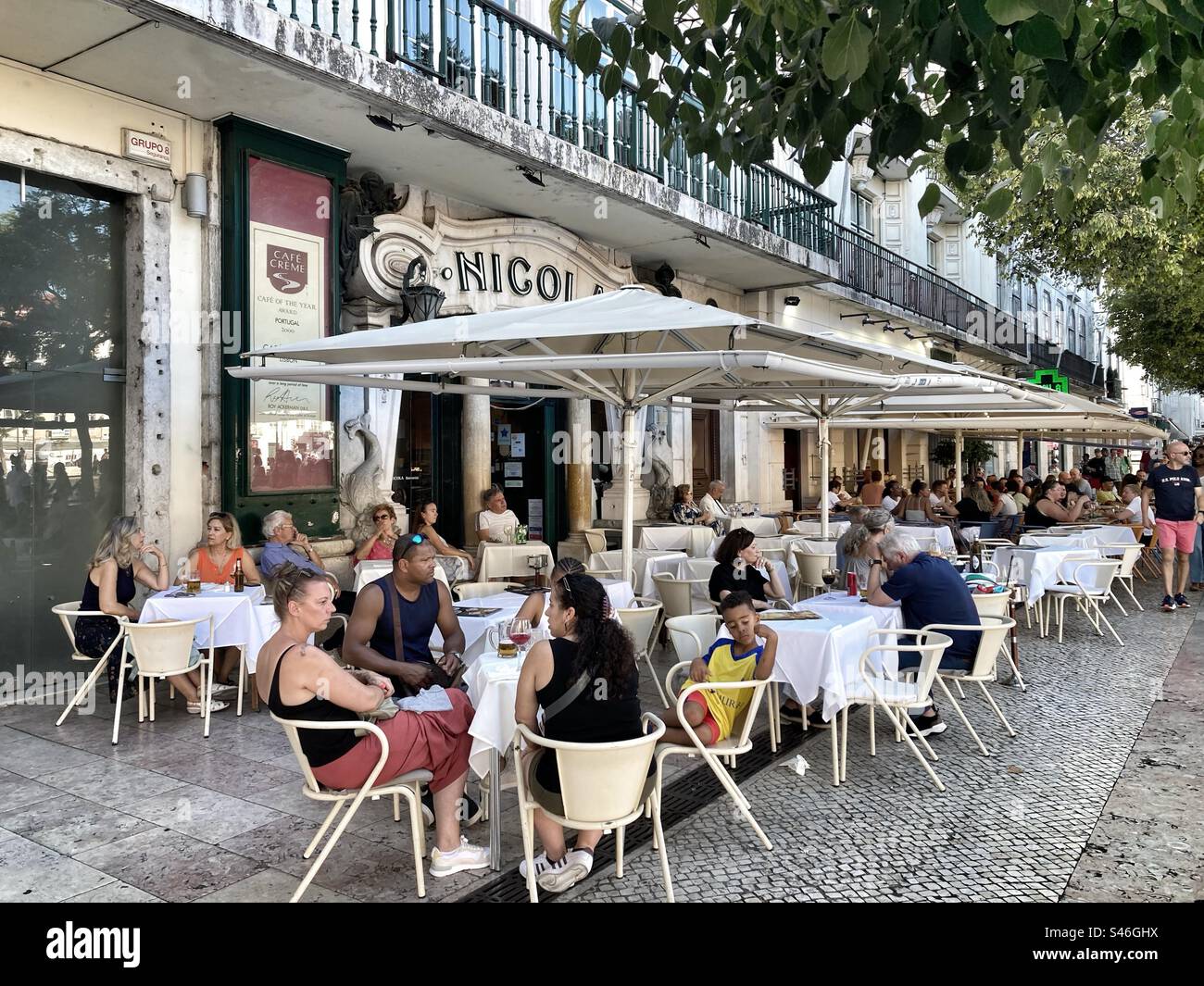 Lateral view of Nicola esplanade’s with tourists/costumers enjoying their time ( food and drinks). Lisbon downtown, atRossio square . Portuguese capital. - Smartphone Captured Stock Image