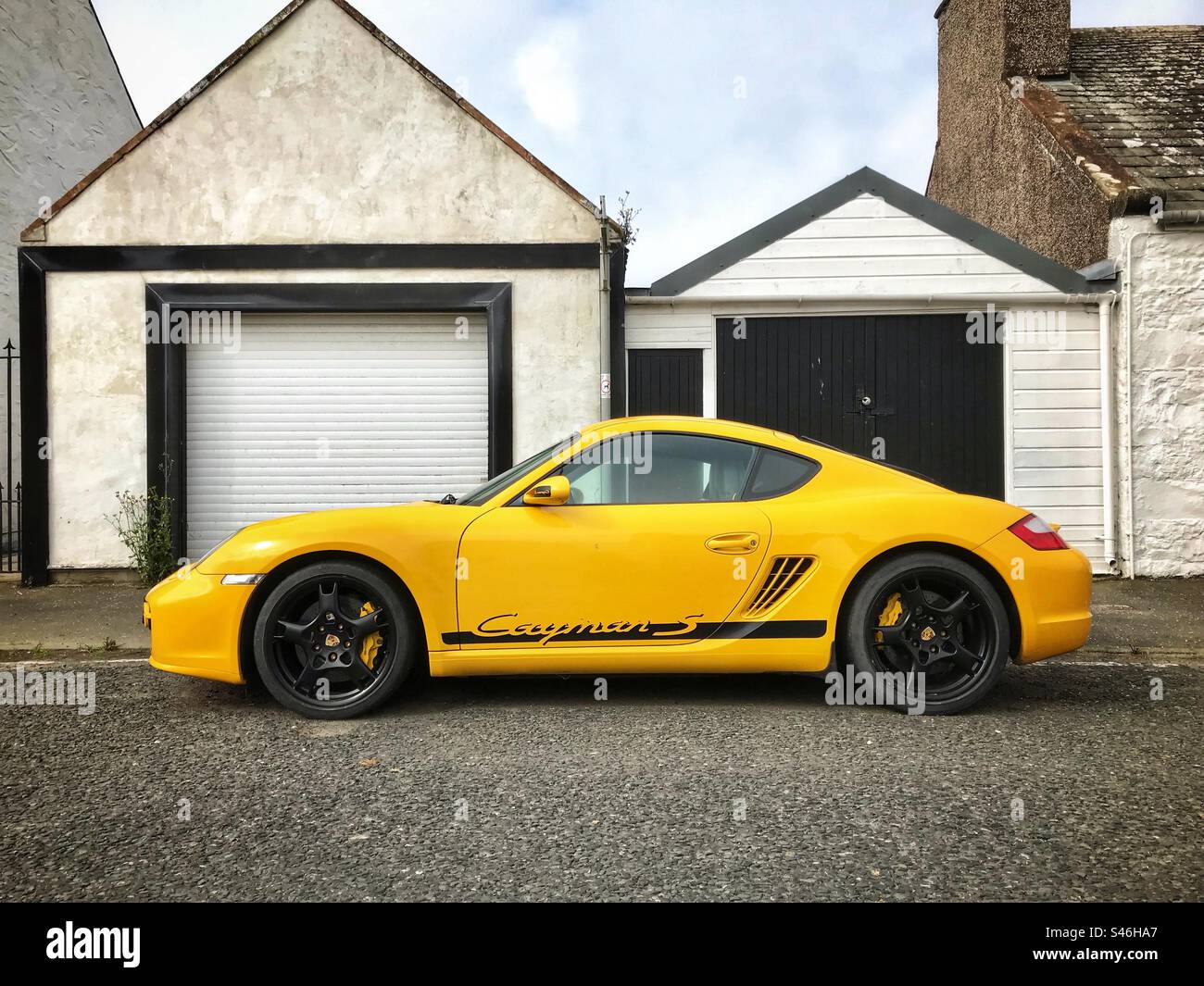 Porsche Cayman S sports car parked outside urban garages - Smartphone Captured Stock Image