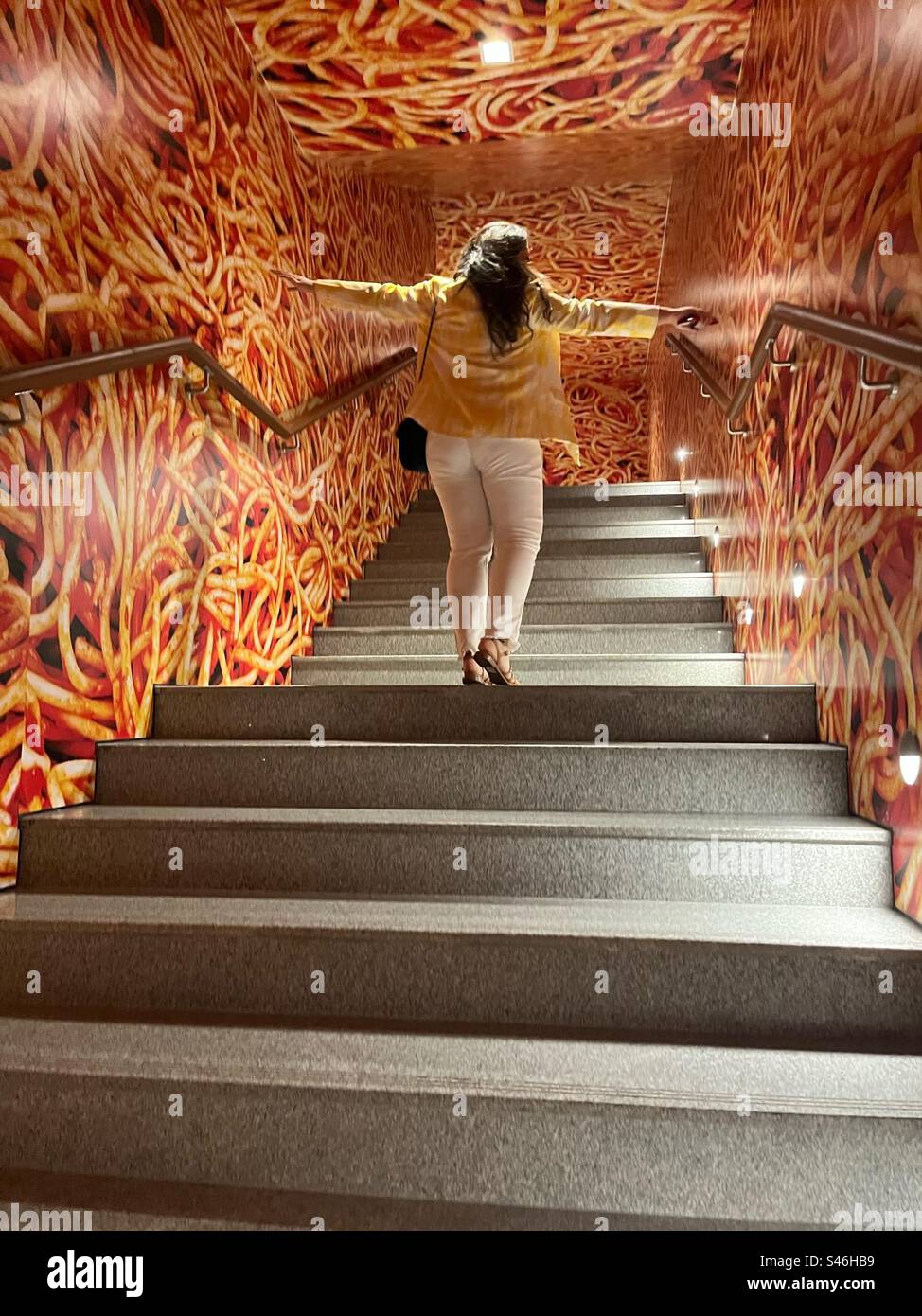 Girl in an art room on the staircase in Mumbai at Toilet Paper Magazine’s art exhibition at the Nita Mukesh Ambani Cultural Center Stock Photo