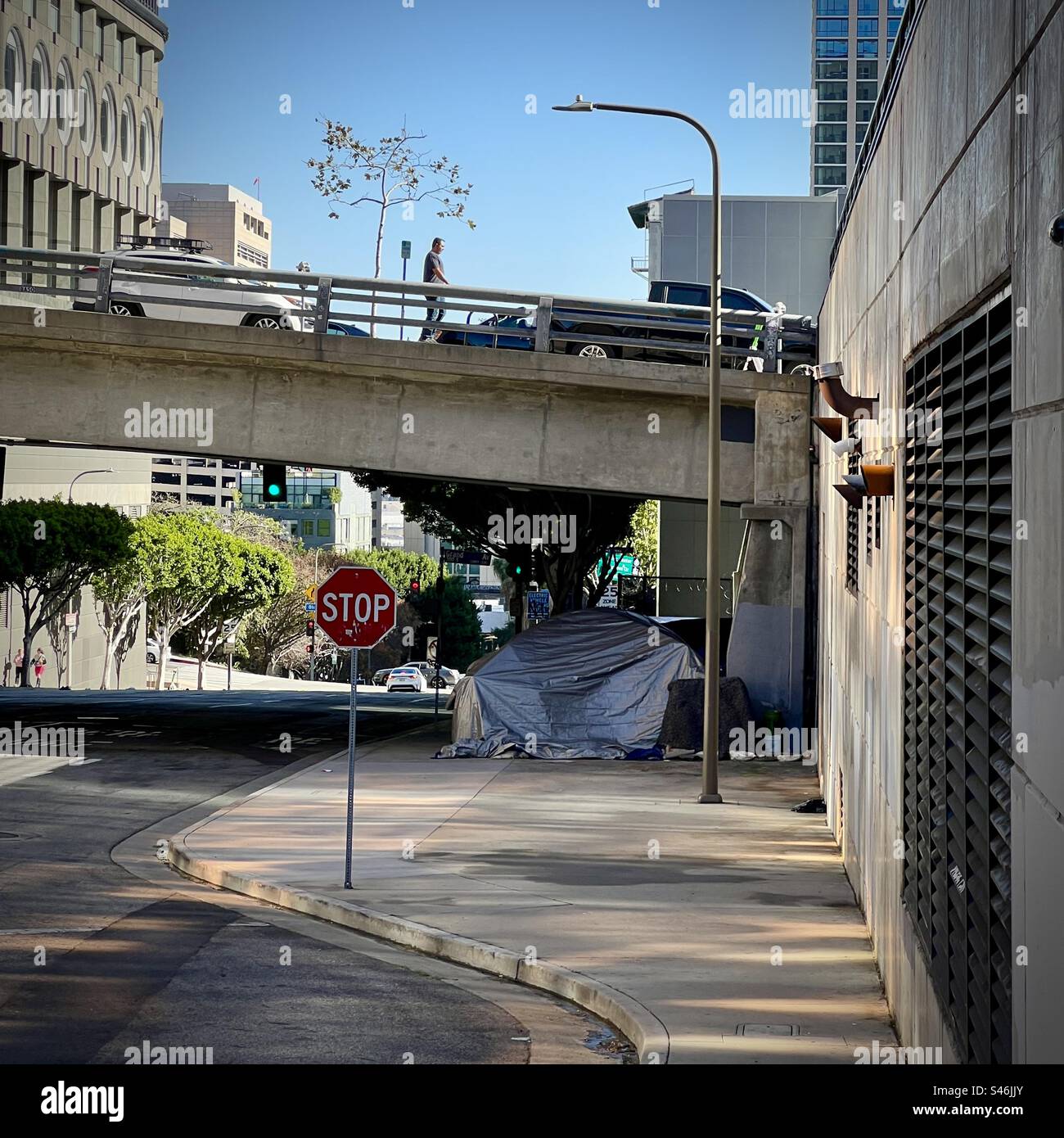 LOS ANGELES, CA, JAN 2023: homeless encampment under a bridge, next to quiet road in the financial district of Downtown - Smartphone Captured Stock Image