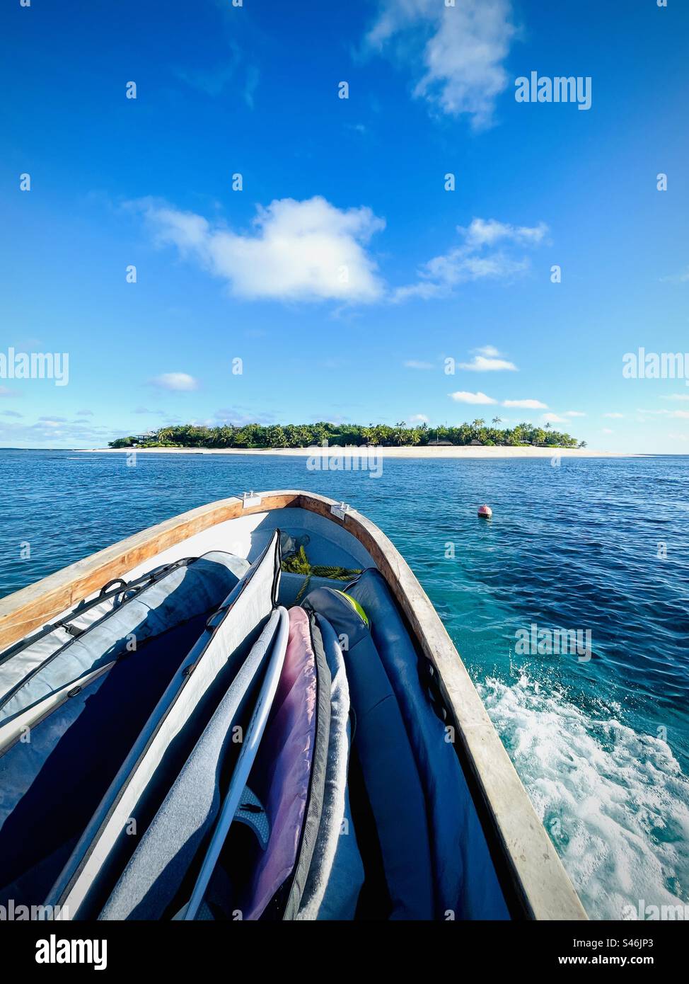 A boat filled with surfboards coming back to the island. Tavarua Island Resort, Fiji. - Smartphone Captured Stock Image