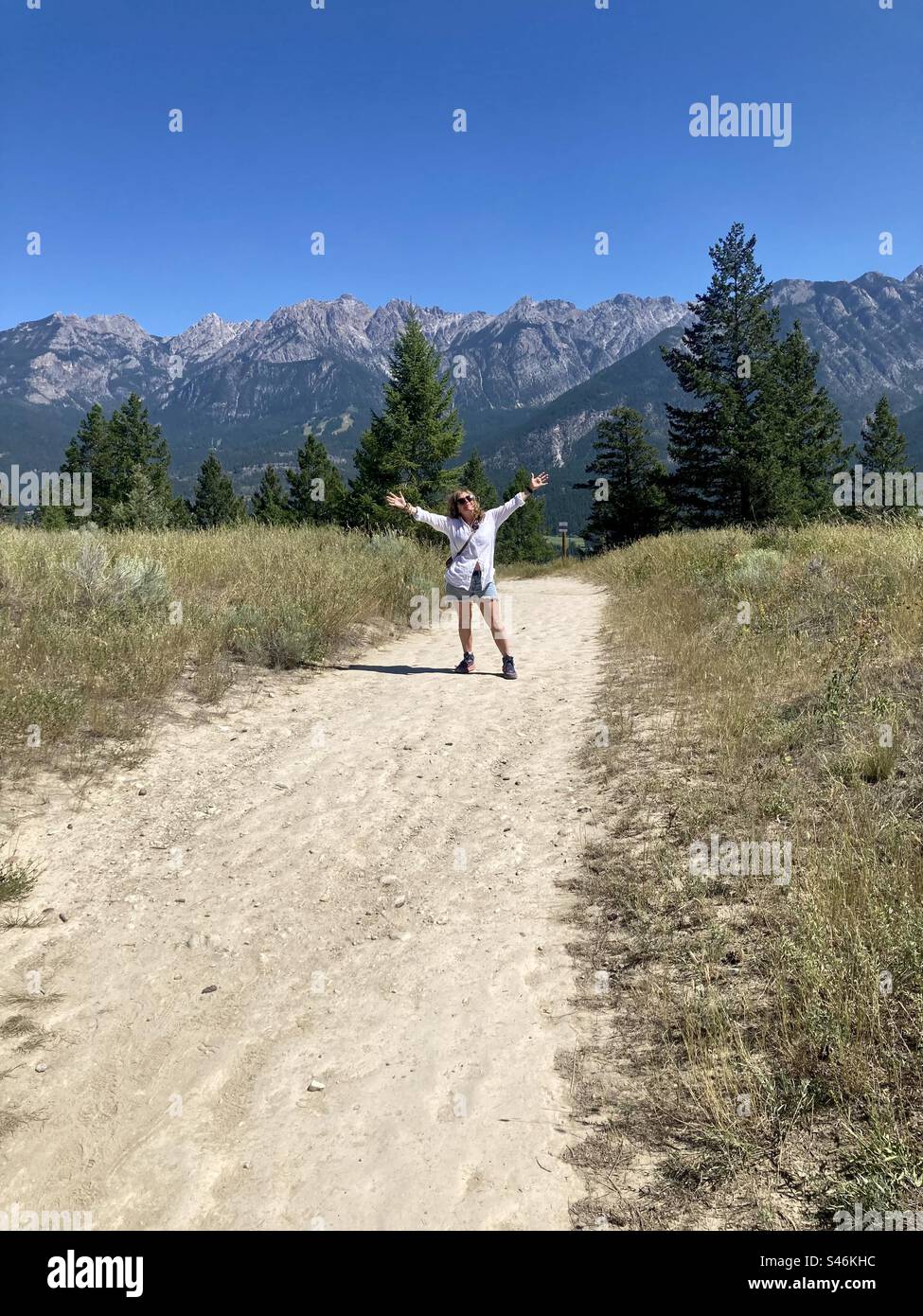 Woman with outstretched arms hiking the Hoodoo Trail near Fairmont Hot Springs. - Smartphone Captured Stock Image