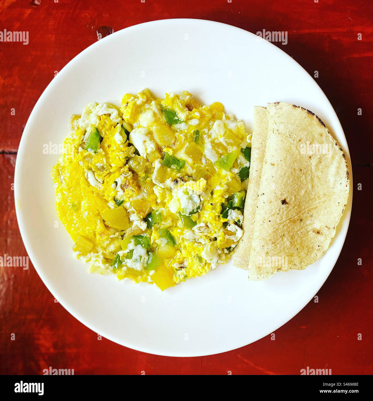Fried potatos, eggs and green chilli peppers and two corn tortillas in Queretaro, Mexico - Smartphone Captured Stock Image