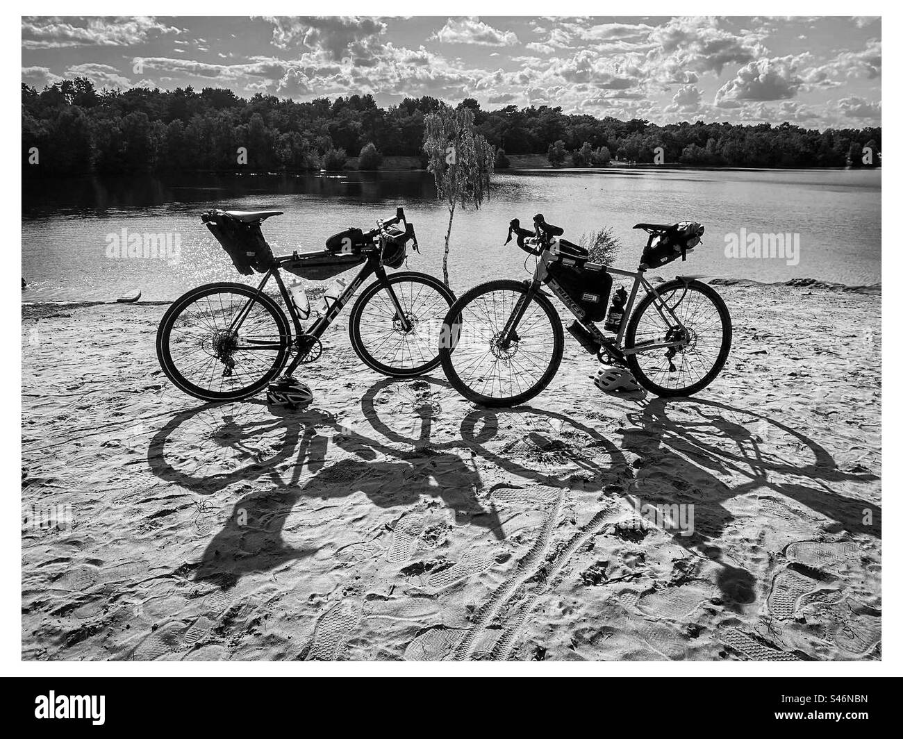 Two adventure bikes parked by a lake in Norfolk near Kings Lynn in England in the Summer - Smartphone Captured Stock Image