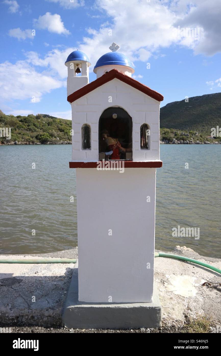 Miniature church called a kandylakia, found at the side of the road overlooking the water in Greece. - Smartphone Captured Stock Image