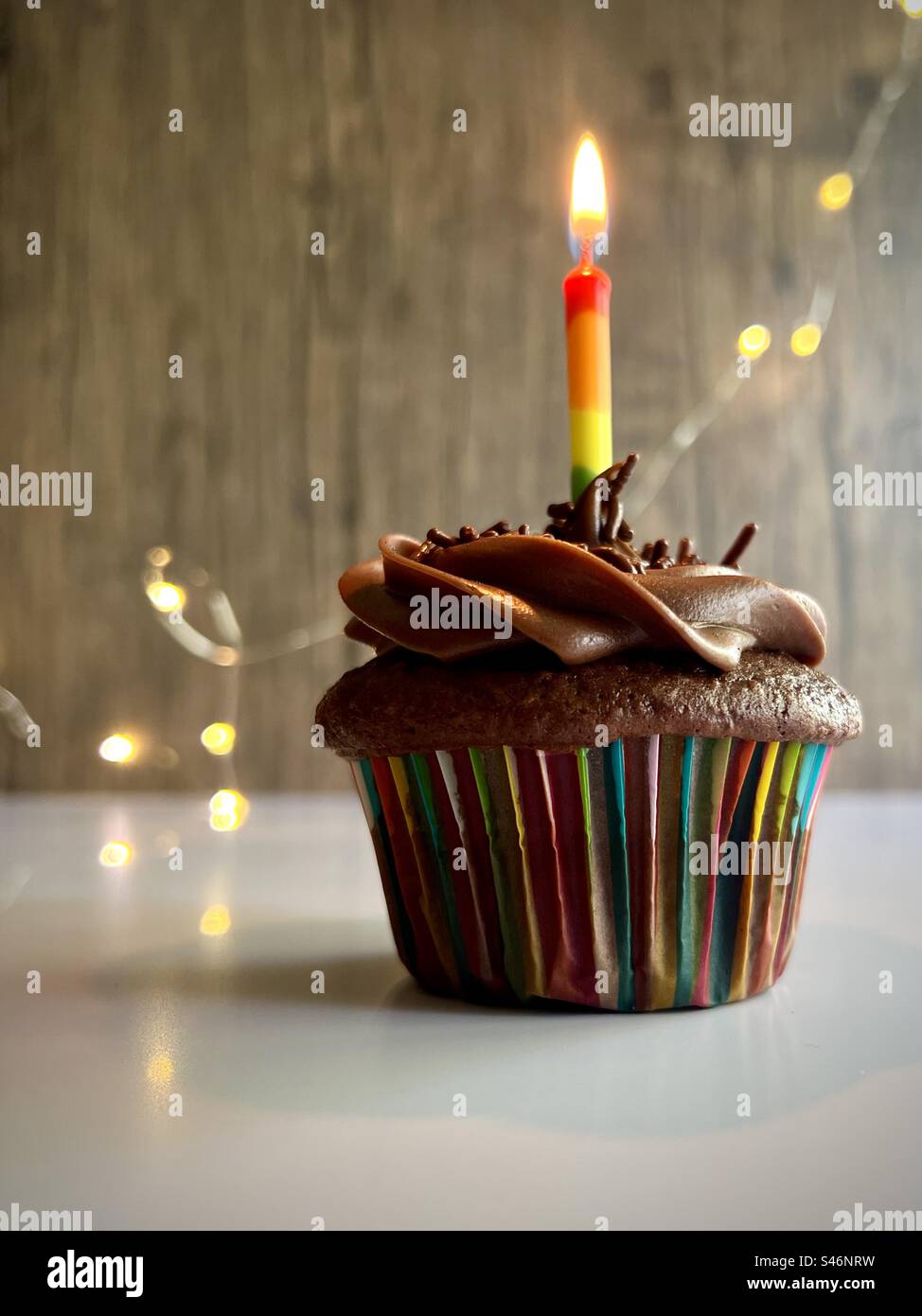 Chocolate cupcake with rainbow candle Stock Photo