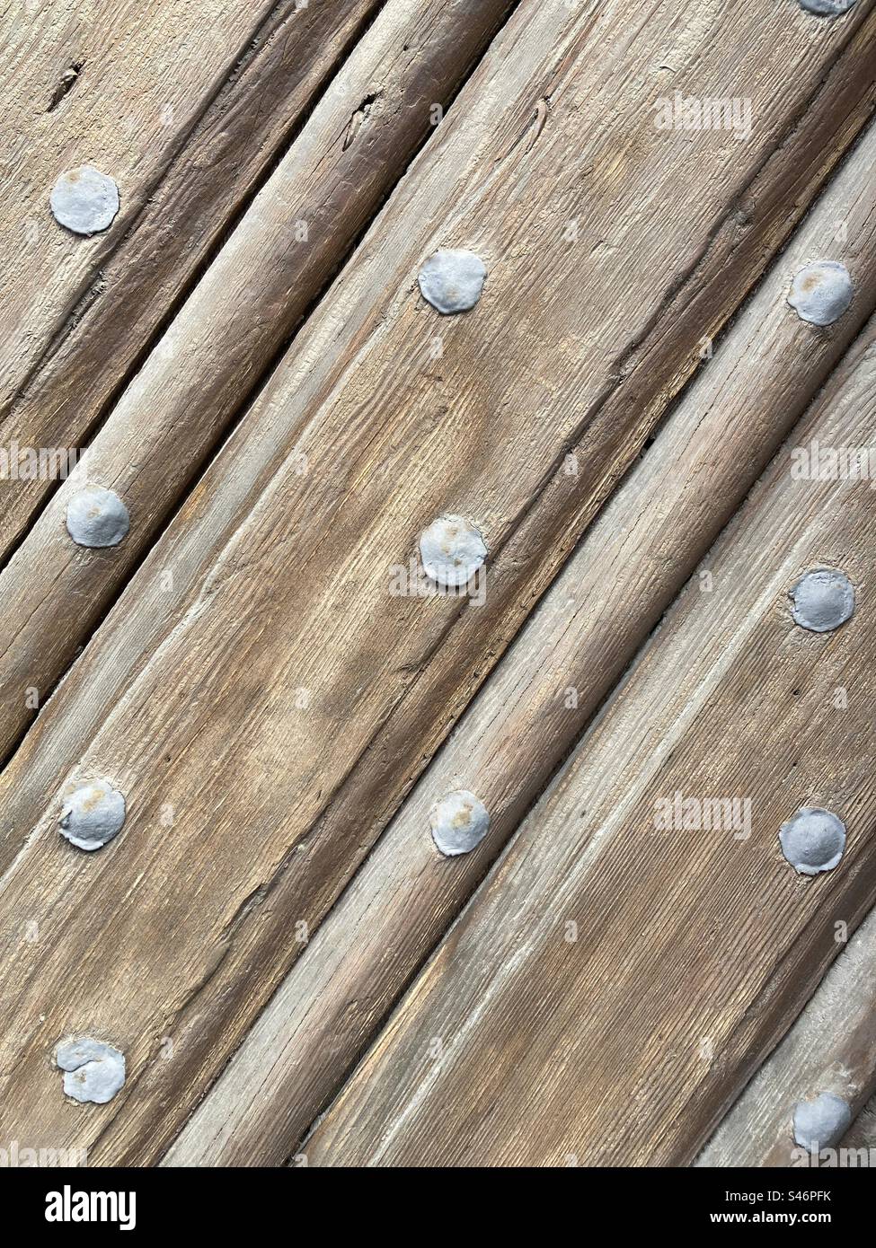Old diagonal wooden planks with gray metal rivets - Smartphone Captured Stock Image