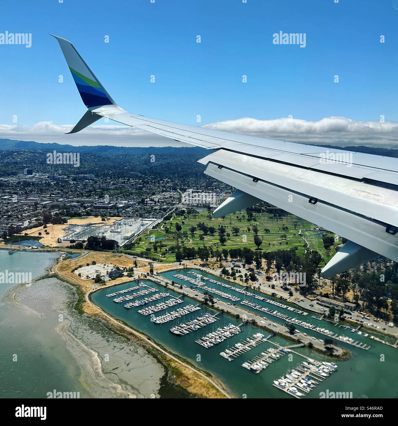 June, 2023, Airplane wing during descent over San Mateo, towards San Francisco International Airport, California, United States - Smartphone Captured Stock Image