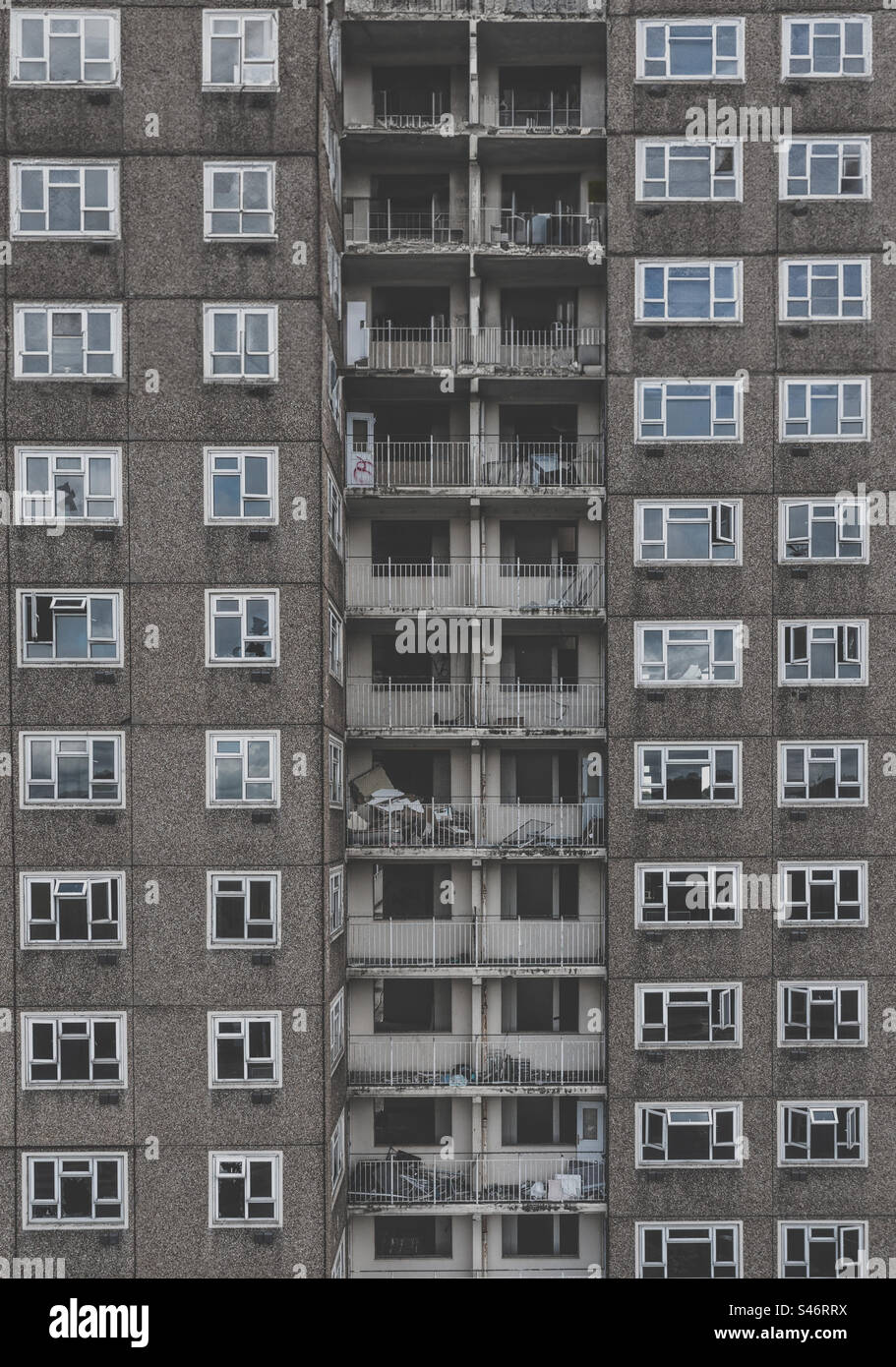 Full frame architecture background of an old and condemned derelict tower block in the UK  from the Sixties with concrete walls and old balconies with broken windows Stock Photo