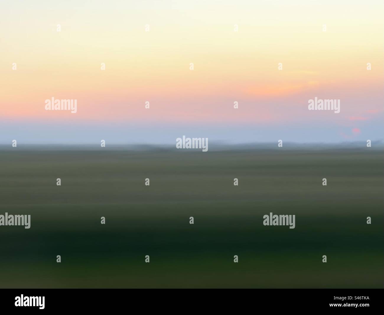 Long exposure of field at sunset seen through window of a moving car - Smartphone Captured Stock Image