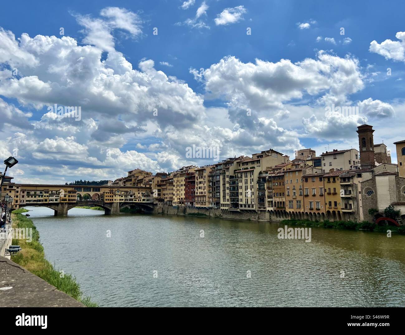 Ponte Vecchio spanning the Arno River and  buildings along the waters edge in Florence, Italy. - Smartphone Captured Stock Image