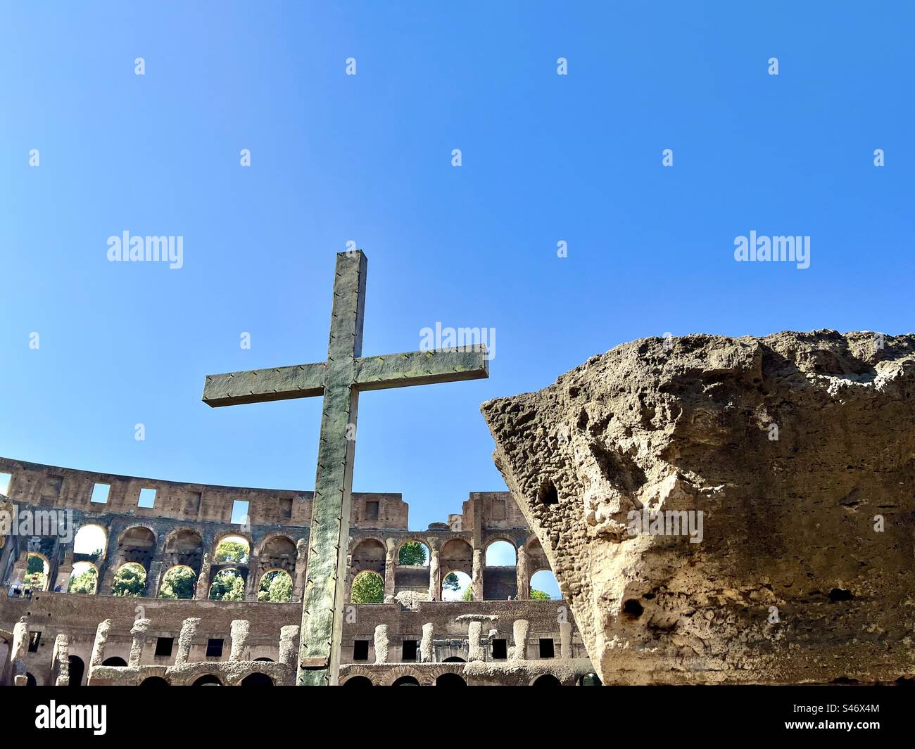 A cross inside the Colosseum commemorates the Christian martyrs who were sacrificed in the ancient Roman arena. It was put there by Pope John Paul II in 2000. Stock Photo