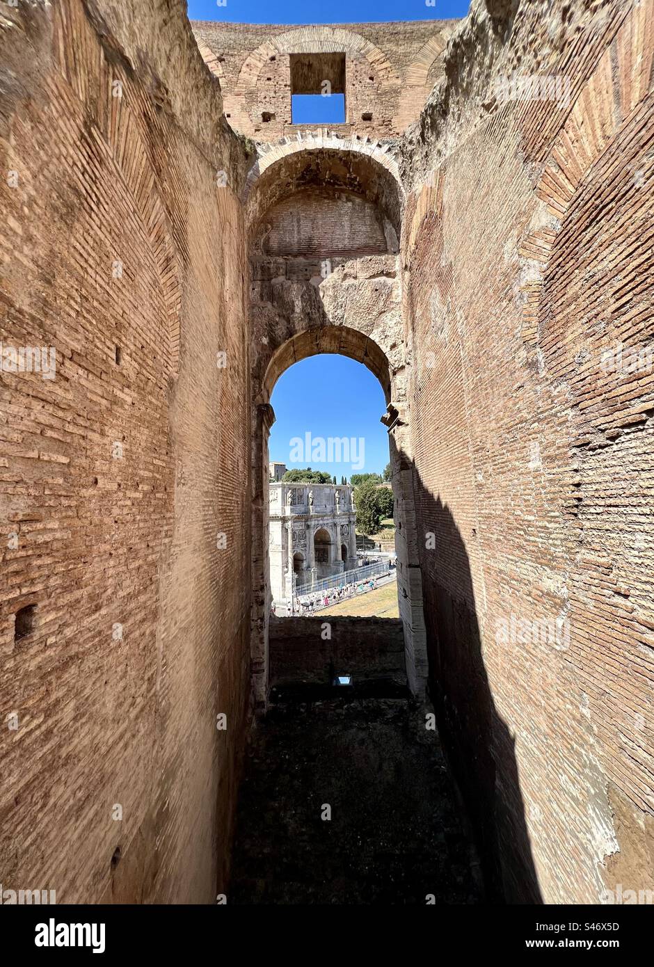 Arch of Constantine viewed through an opening of the Roman Colosseum. - Smartphone Captured Stock Image