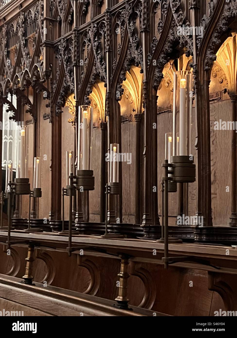 Inside the nave at Norwich cathedral with historical wood work and flickering candela Stock Photo