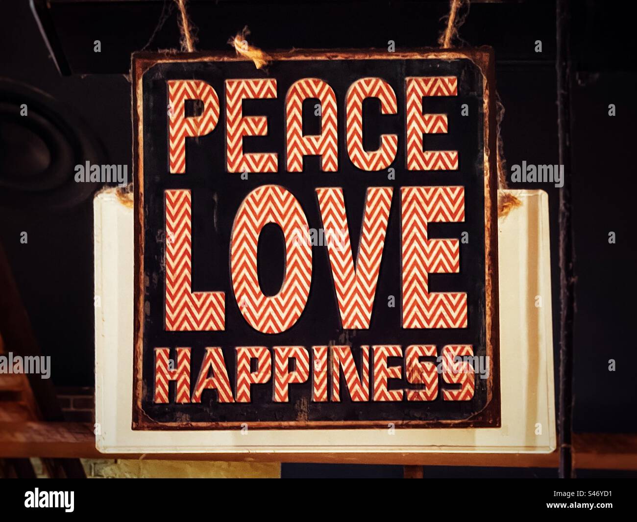 Hanging vintage style sign with the words: ‘ Peace’, ‘Love’ and ‘ Happiness’. - Smartphone Captured Stock Image