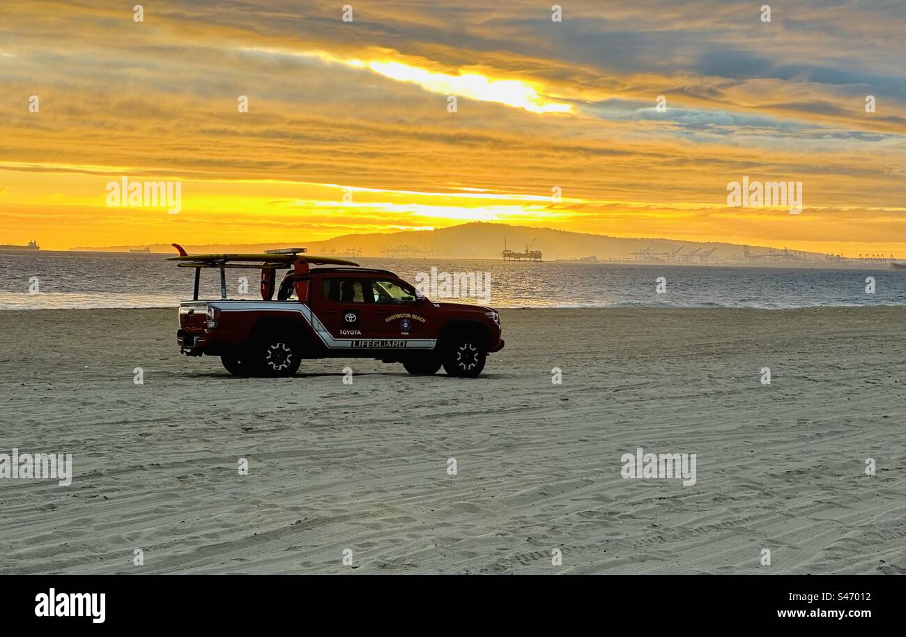 Huntington Beach (California) Fire Department lifeguard truck on the sand of Subset Beach at sunset. Stock Photo