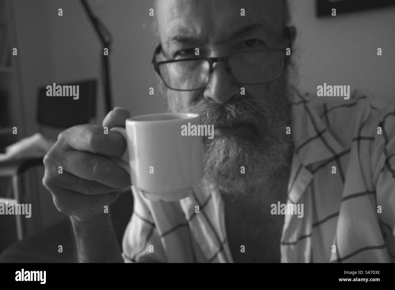 Senior man drinking coffee at night Stock Photo