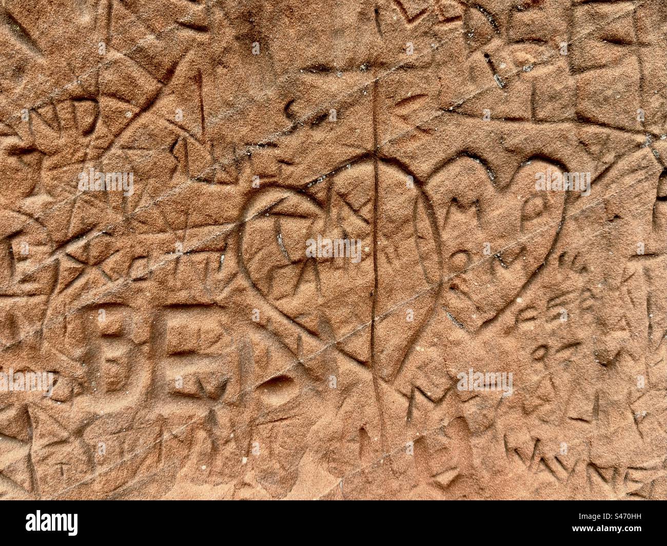 Graffiti of linked hearts scratched in the red sandstone of Kinver in Staffordshire Stock Photo