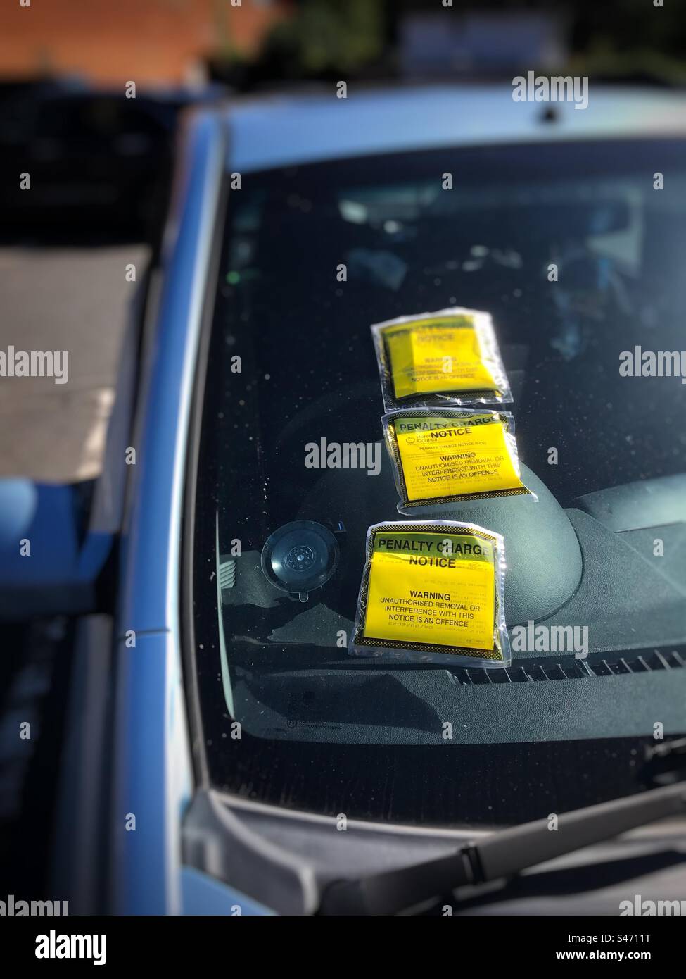 A parked car with three parking tickets - Smartphone Captured Stock Image