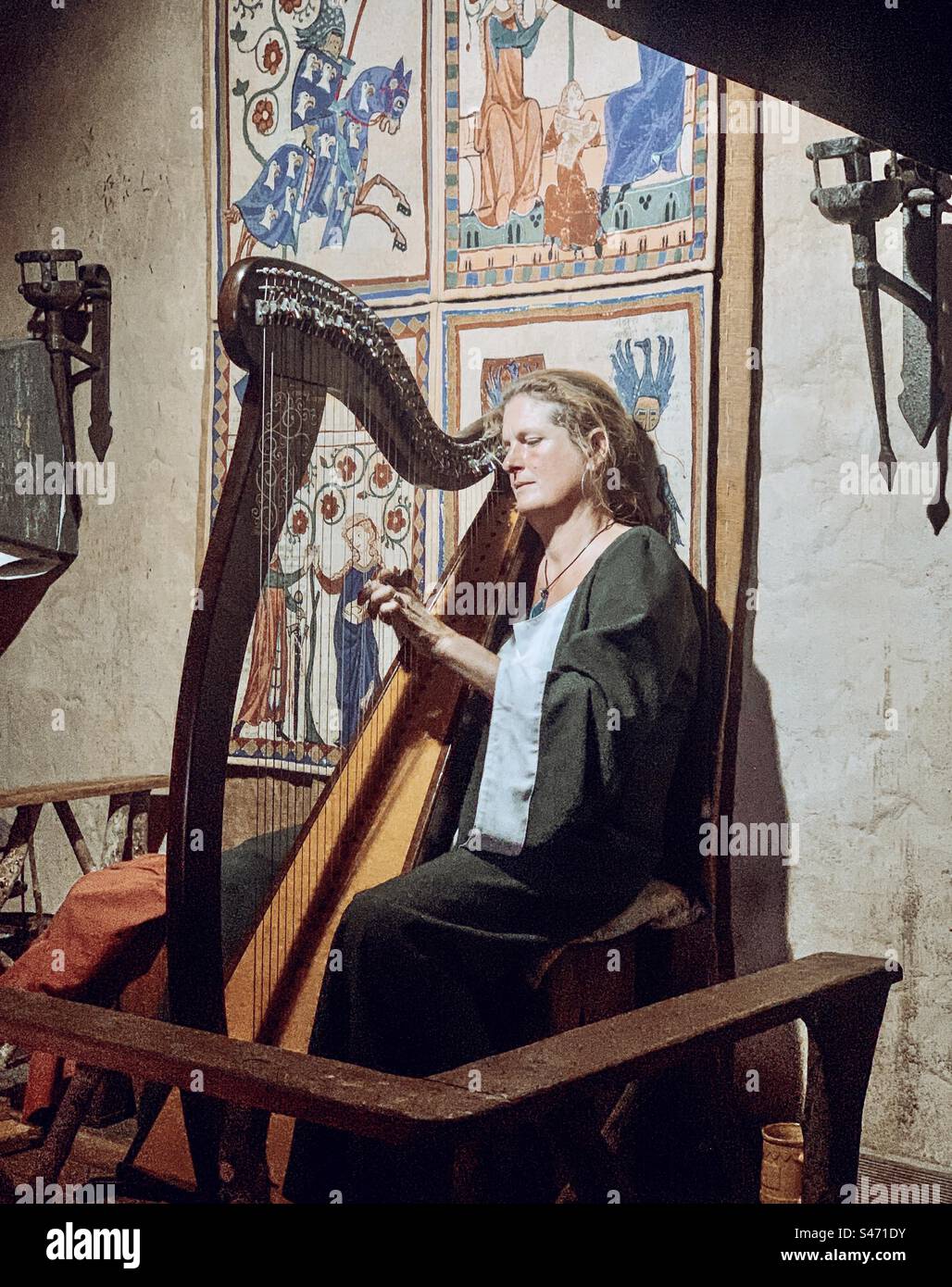 Woman playing the harp in mediaeval dress and setting - Smartphone Captured Stock Image