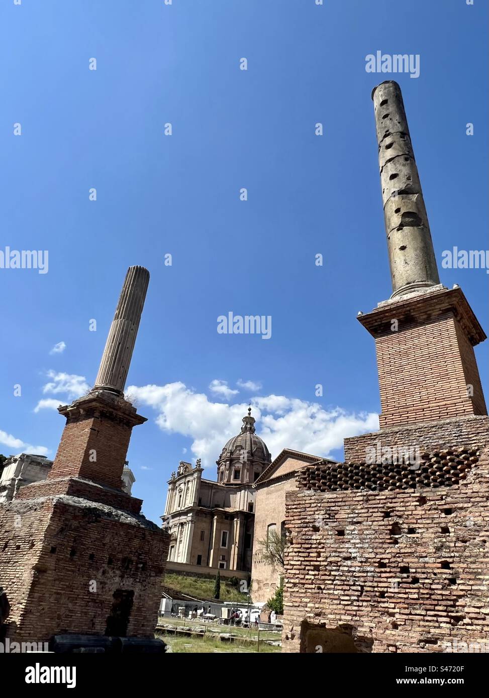 Colonne tetrarchiche and Colonne dei decannalia at the Roman Forum. Chiesa Santi Luca and ancient senate house are in the background. - Smartphone Captured Stock Image