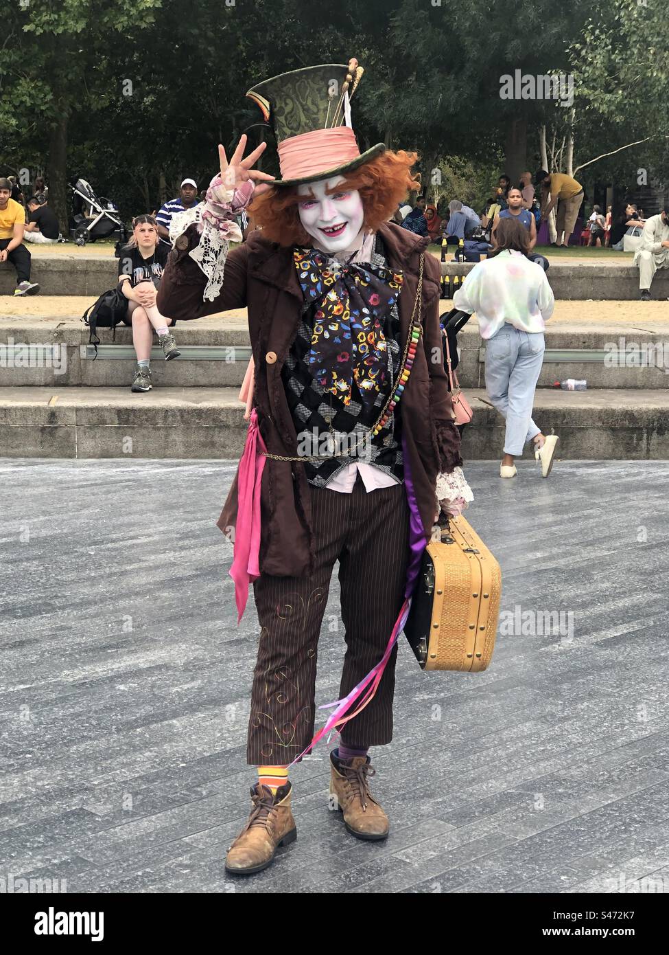A street artist impersonating the Hatter fro Alice in Wonderland on the banks of the Thames River - Smartphone Captured Stock Image