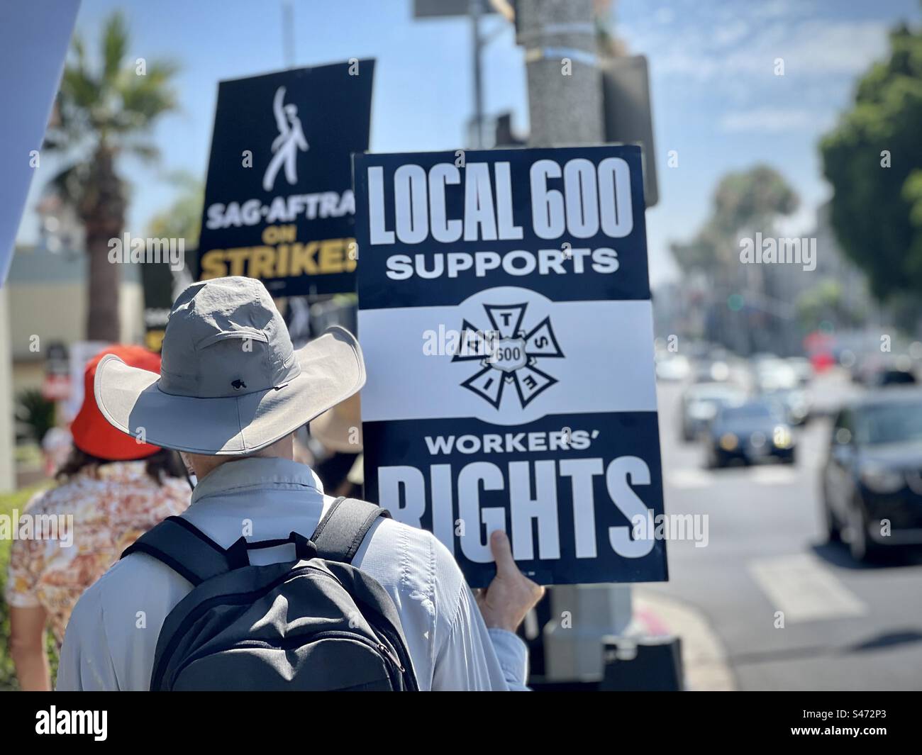 LOS ANGELES, CA, AUG 15, 2023: member of the IATSE Local 600, camera union, walks picket line in support of striking writers and actors, outside gates at Paramount Pictures Studios, Hollywood - Smartphone Captured Stock Image