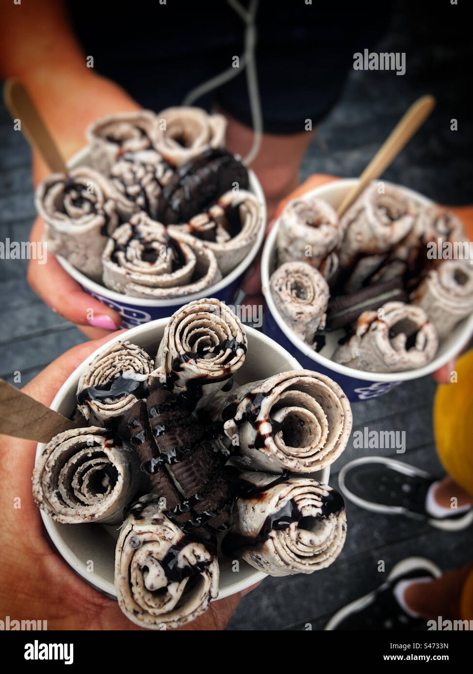 Children on holiday in London during a heatwave in the month of August enjoying rolled ice cream on the South Bank - Smartphone Captured Stock Image