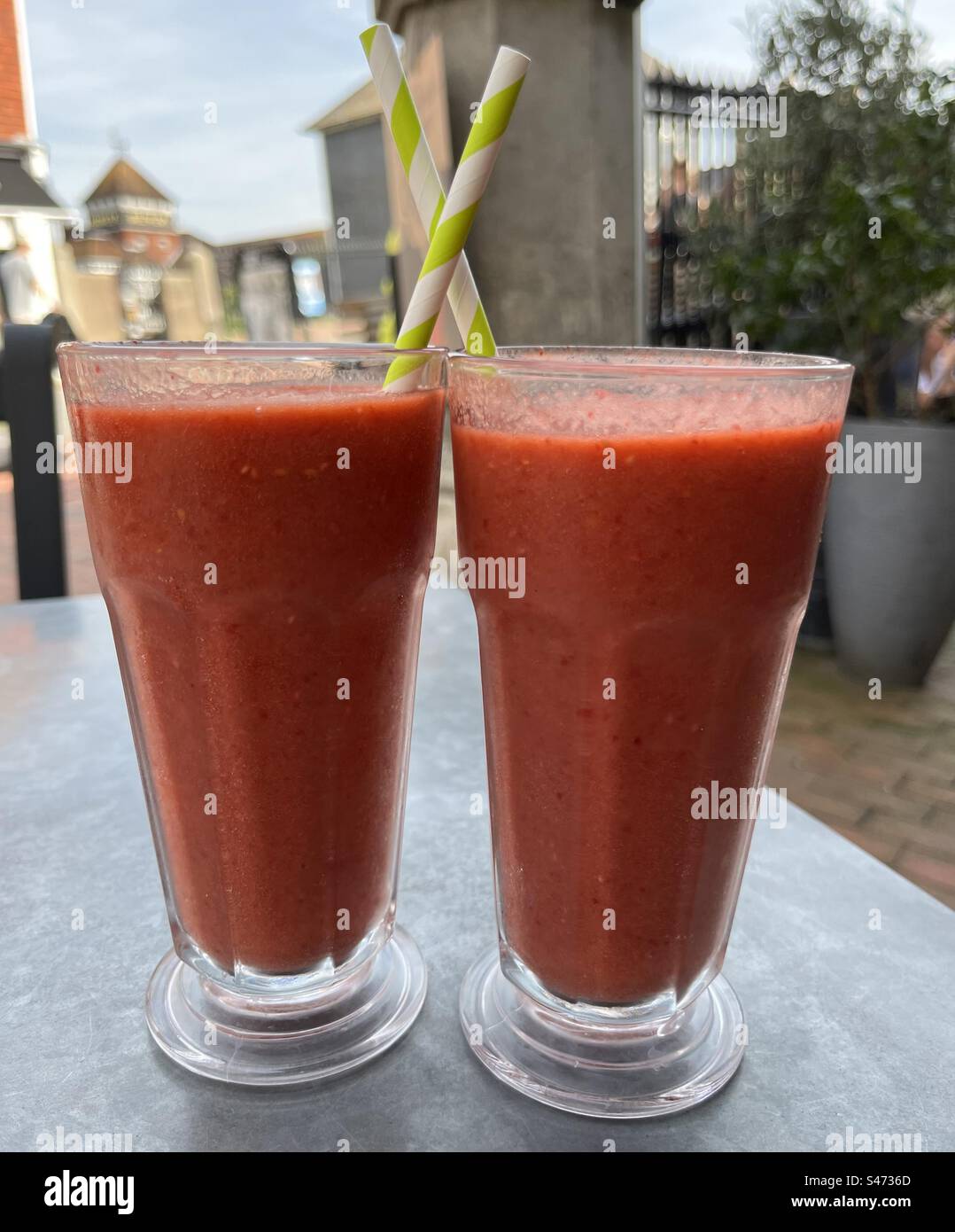 Two Refreshing Raspberry Smoothies on a Cafe Table, a Cool Summer Drink - Smartphone Captured Stock Image