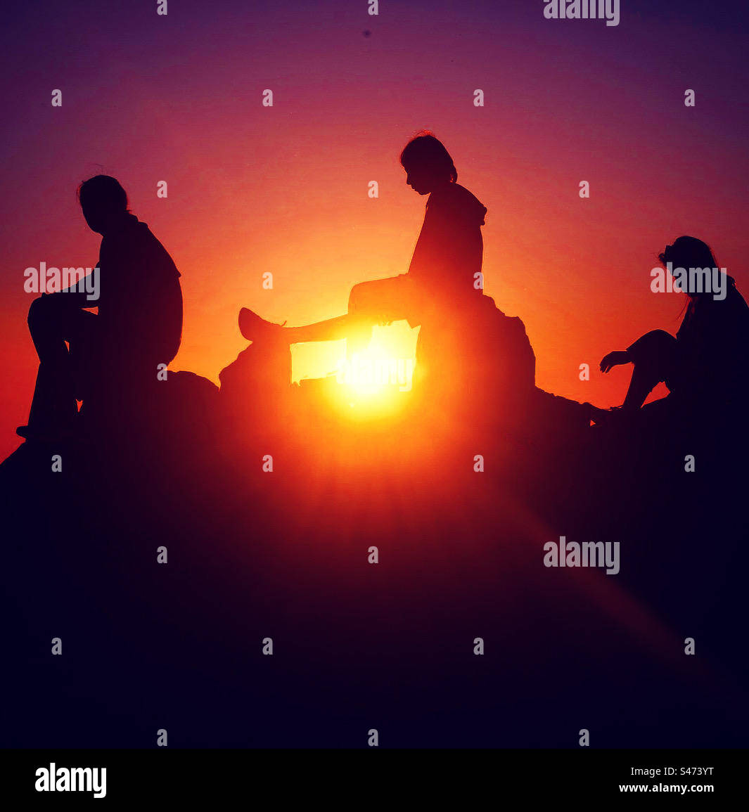 warm sunset with 3 silhouettes in backlight shadow - Smartphone Captured Stock Image