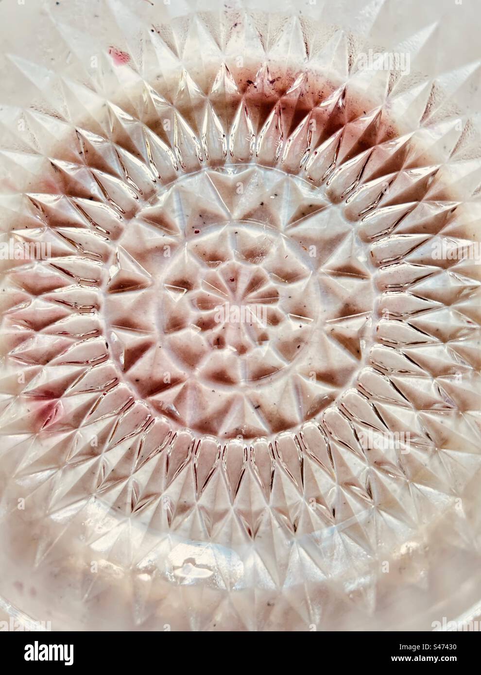 Abstract circular pattern of purple blackberry juice in an ornate glass bowl. - Smartphone Captured Stock Image