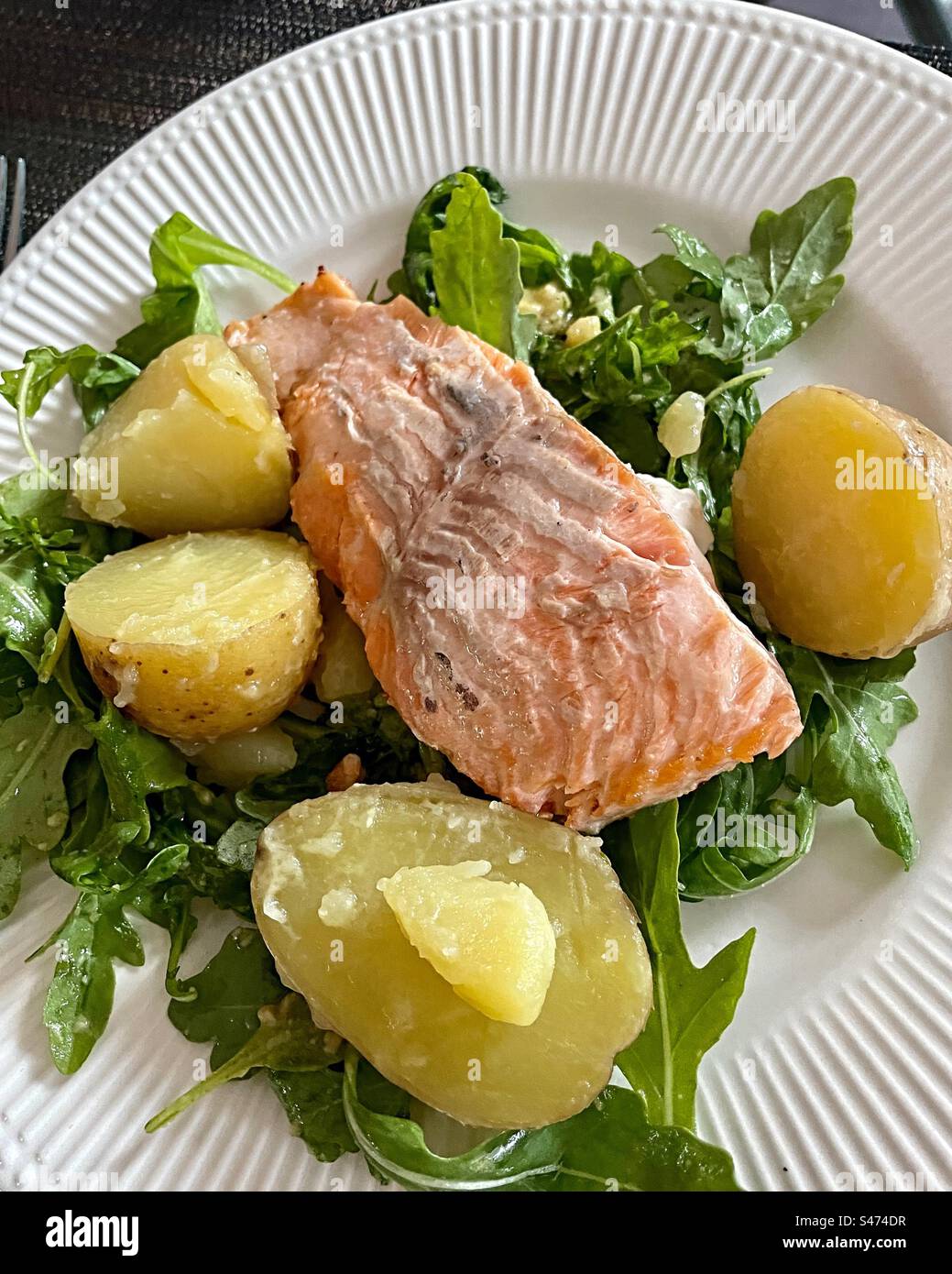 Close up of a gourmet entrée of poached, salmon and new potatoes on a bed of spinach, 2023, USA - Smartphone Captured Stock Image