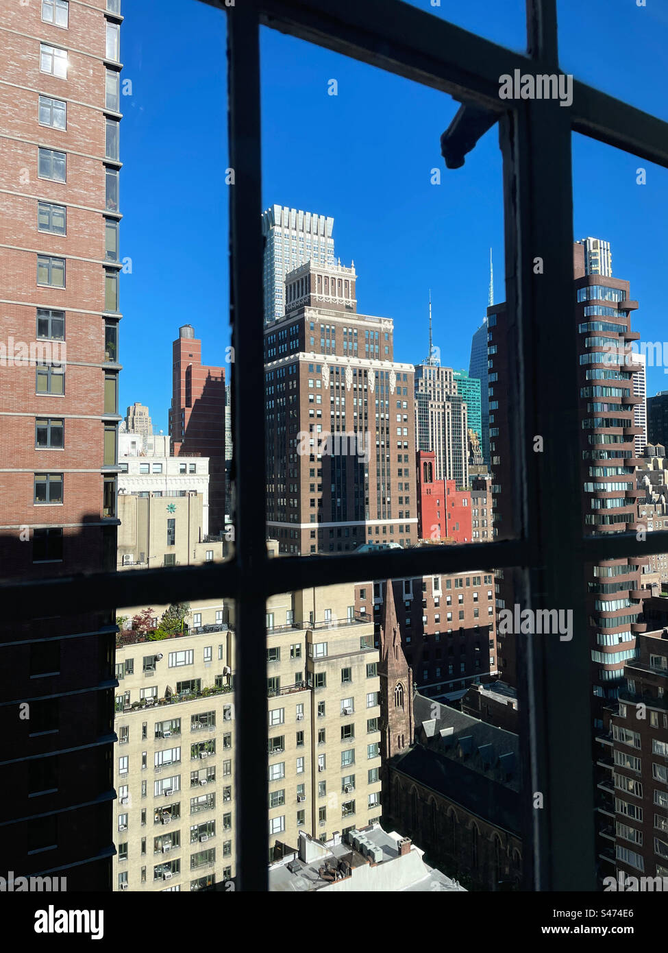 View of Midtown Manhattan skyscrapers through casement window panes in a residential apartment in Murray Hill, 2023, New York City, United States - Smartphone Captured Stock Image