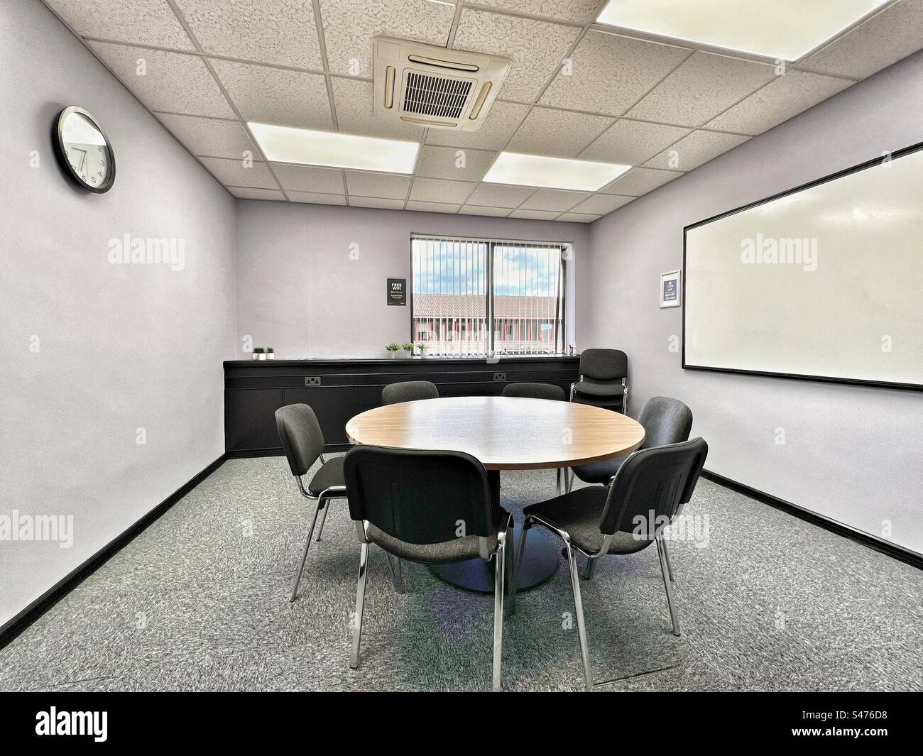 Simple meeting room for six people with table, chairs and large wall mounted whiteboard - Smartphone Captured Stock Image