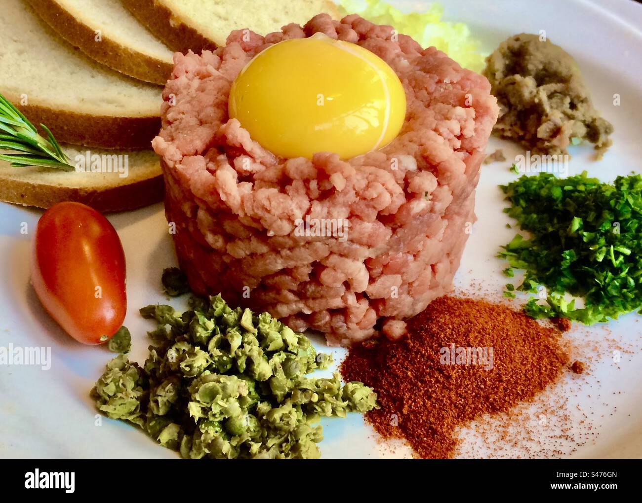 Beef steak tartare traditionally topped with raw egg yolk and served
