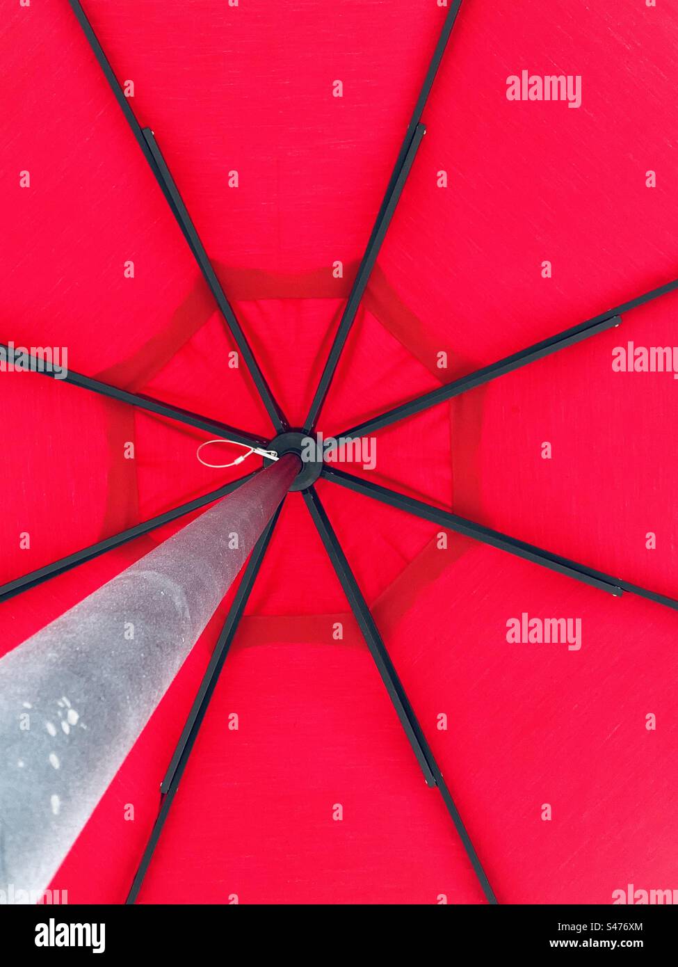 Red cafe umbrella from below. Stock Photo