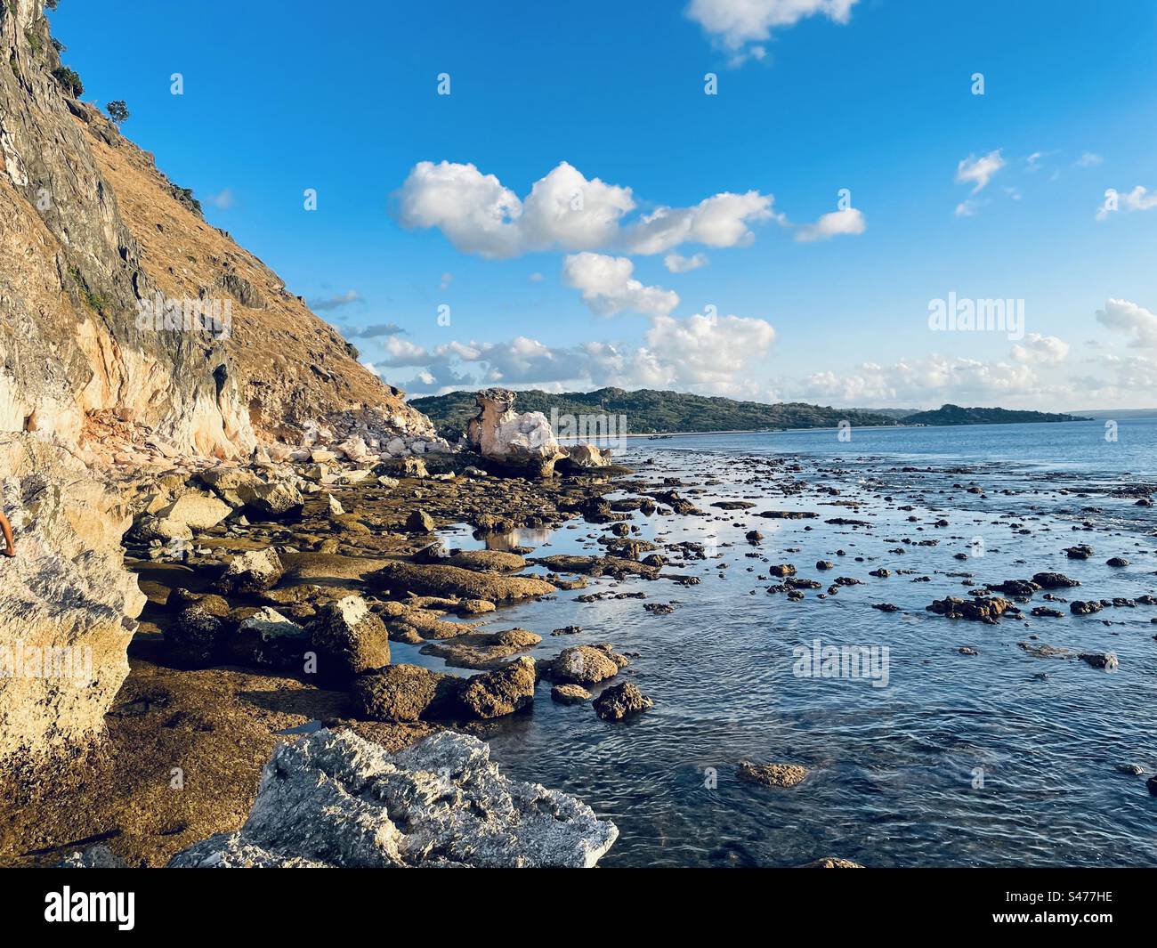 Blue sky, stones, and shallow sea Stock Photo