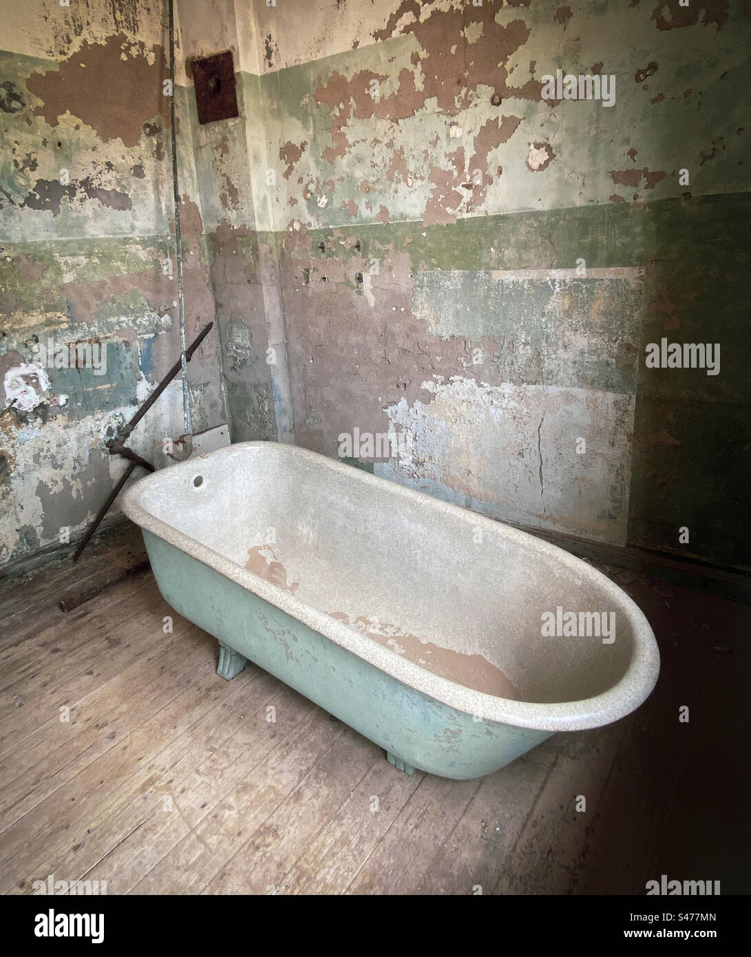 An old bathtub sits in an empty disused bathroom an abandoned building in Southern Namibia - Smartphone Captured Stock Image