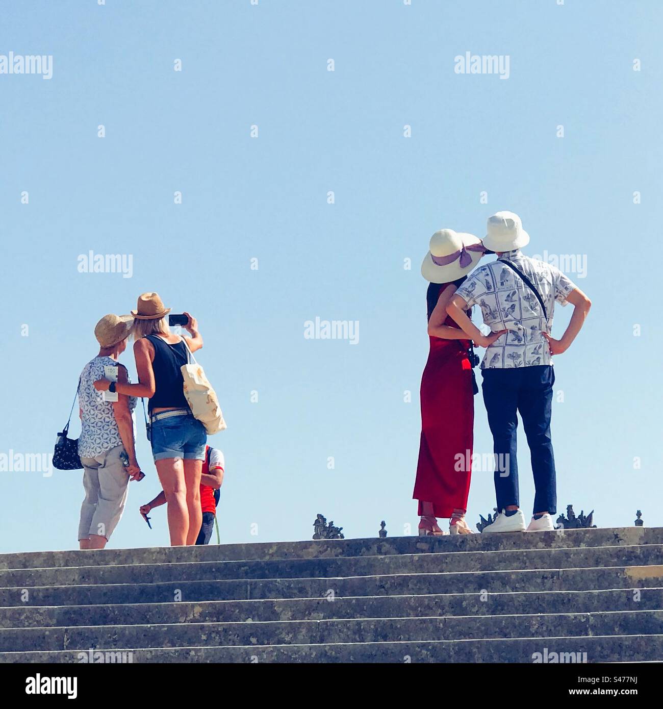 People posing for pictures overlooking the gardens of Versailles - Smartphone Captured Stock Image