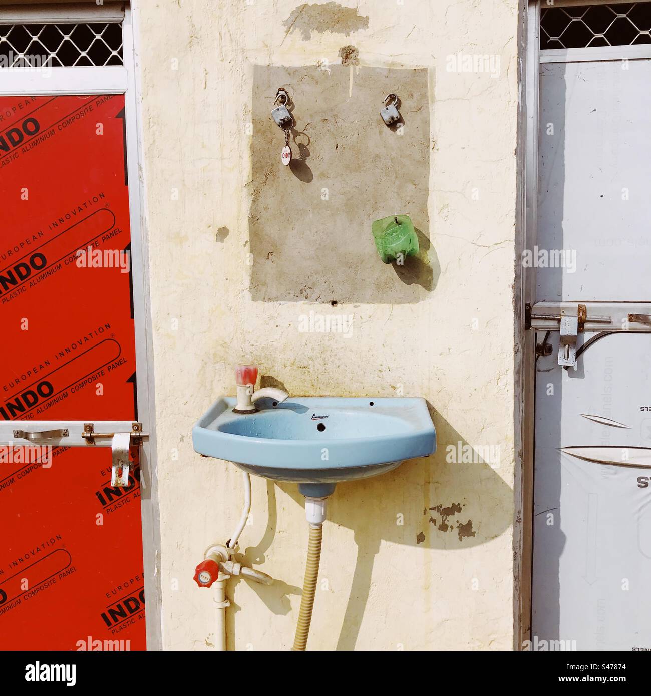 A washbasin outside a couple of public toilets along a highway in India
