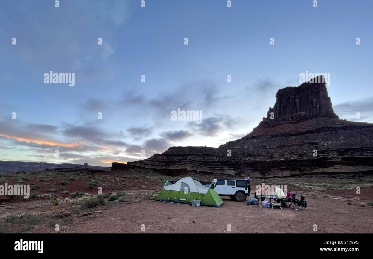 Campers set up their campsite at the base of Airport Tower, a formation along the White Rim Trail in Canyonlands National Park.  Campers are required to camp at designated campsites and need permits. - Smartphone Captured Stock Image