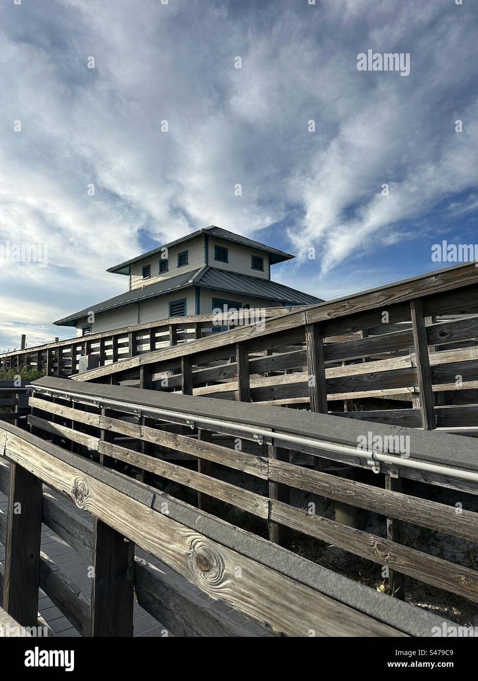 Public beach access with wooden walkway and restroom area at Miramar