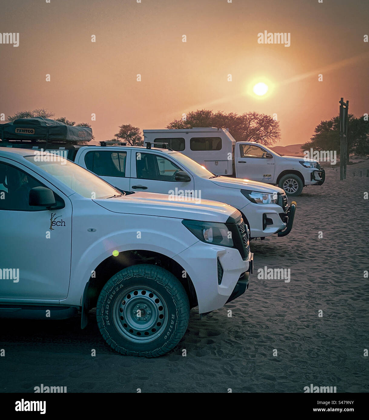 A line of 4 wheel drive cars in a sandy car park in Sossusvlei in Namibia at sunrise - Smartphone Captured Stock Image